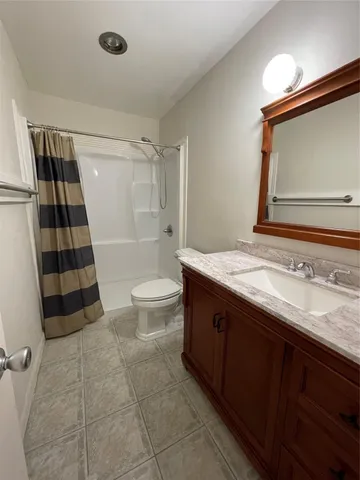 a bathroom with a sink a toilet a mirror and shower