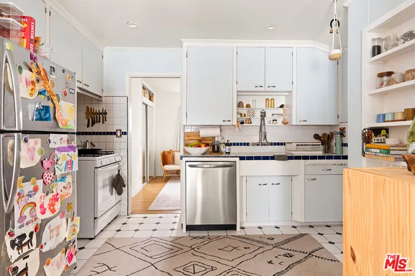 a kitchen with stainless steel appliances granite countertop a refrigerator and a stove top oven