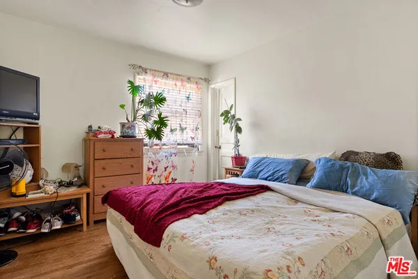 a bedroom with a bed and a potted plant