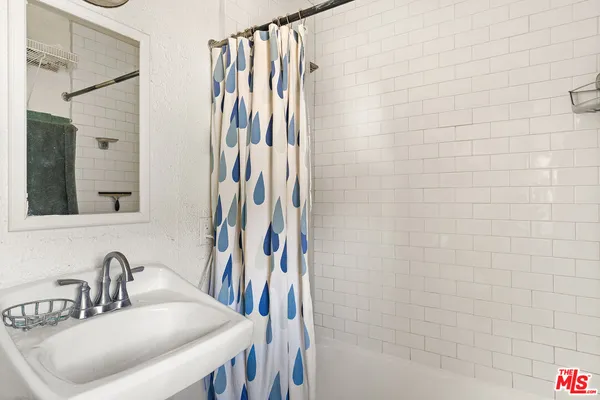 a bathroom with a sink a mirror and shower