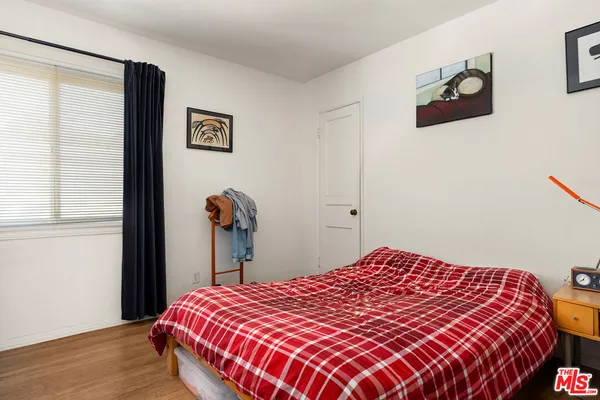 a bedroom with a bed and a painting on the wall