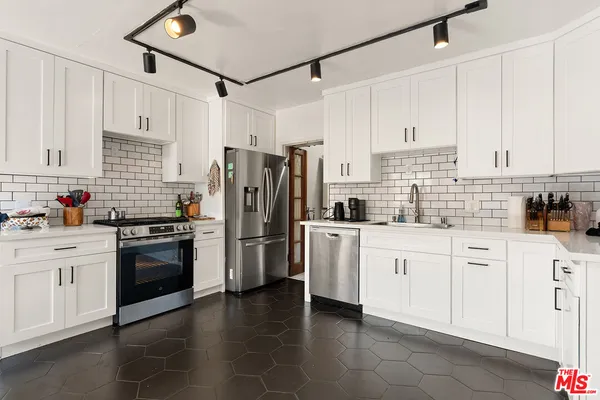 a kitchen with stainless steel appliances and white cabinets