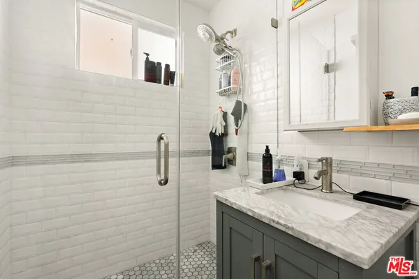 a bathroom with a granite countertop sink a toilet and mirror