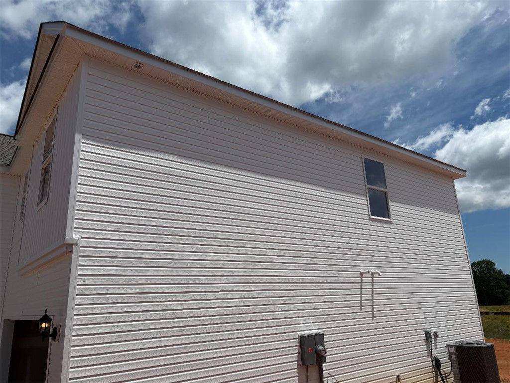129 Cedar Shoals Easley, SC 29640 - Photo 2 of 31 Crisp white siding complements the clear blue sky, presenting a neat and ready-to-finish exterior.