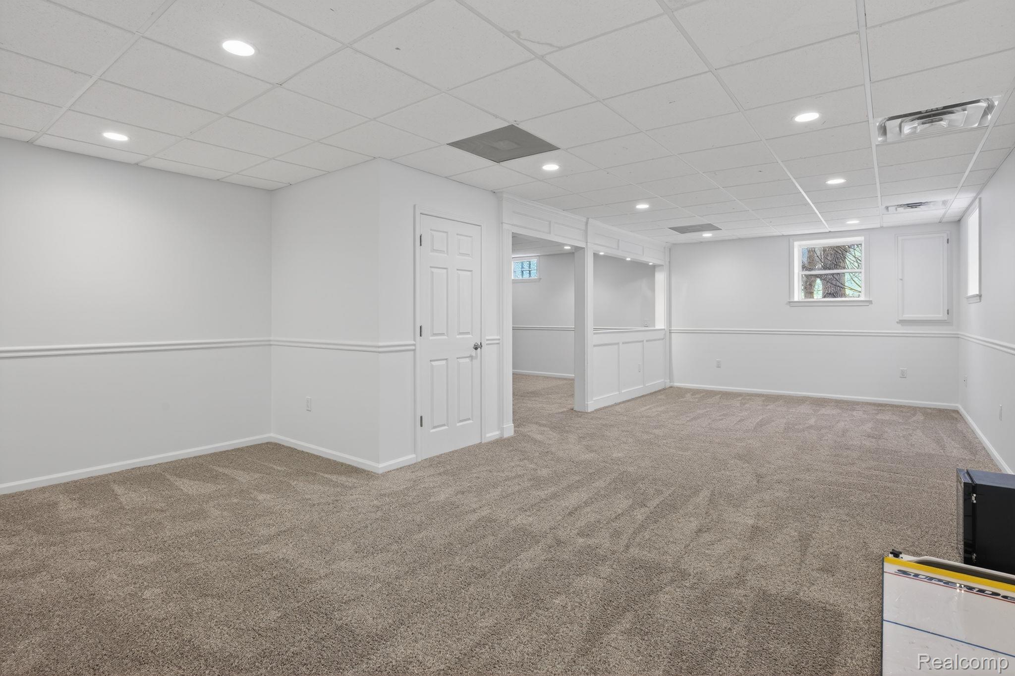 9055 Hegel Road Grand Blanc, MI 48439 - Photo 48 of 62 Spacious room featuring neutral carpet flooring, recessed lighting, and white walls with wainscoting