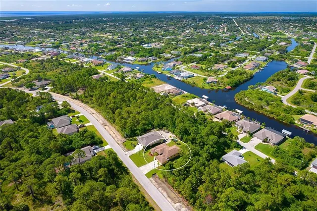 an aerial view of residential houses with outdoor space and trees