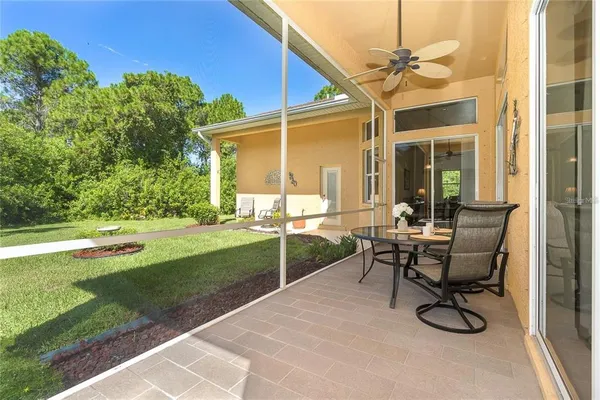 a view of a patio with table and chairs with wooden floor and fence