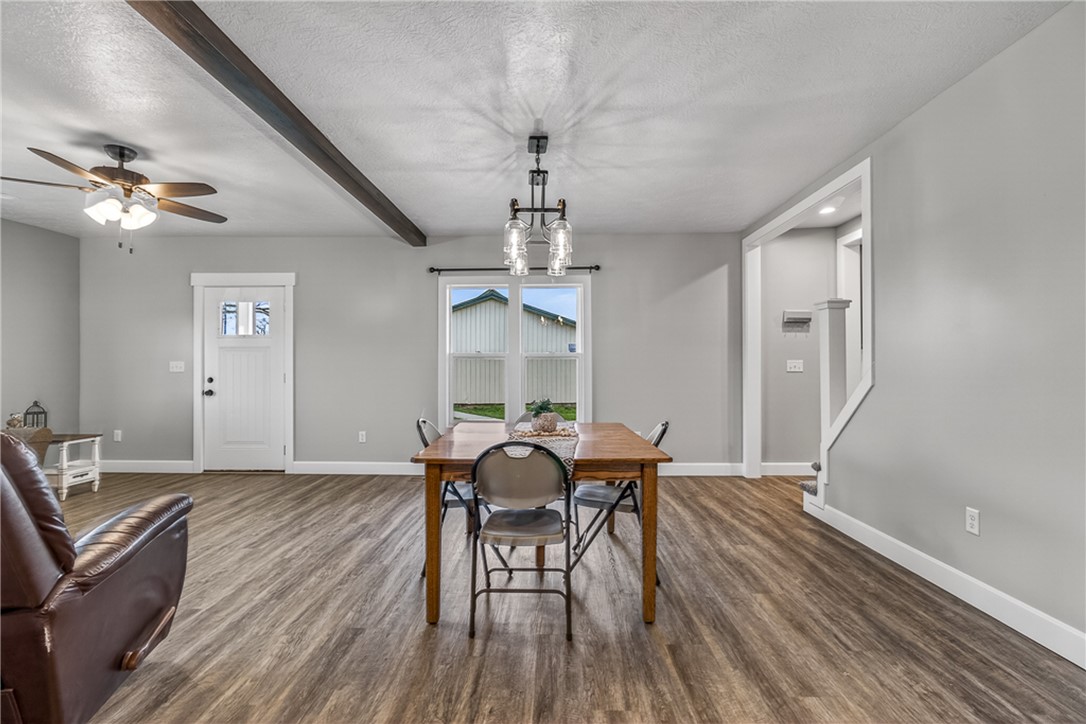 8700 Quaker Trace Road Camden, OH 45311 - Photo 5 of 34 An inviting open-concept area featuring warm wood-look flooring and exposed beam details.