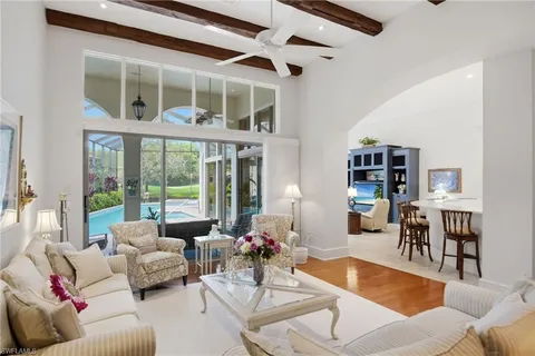 a living room with furniture and floor to ceiling windows