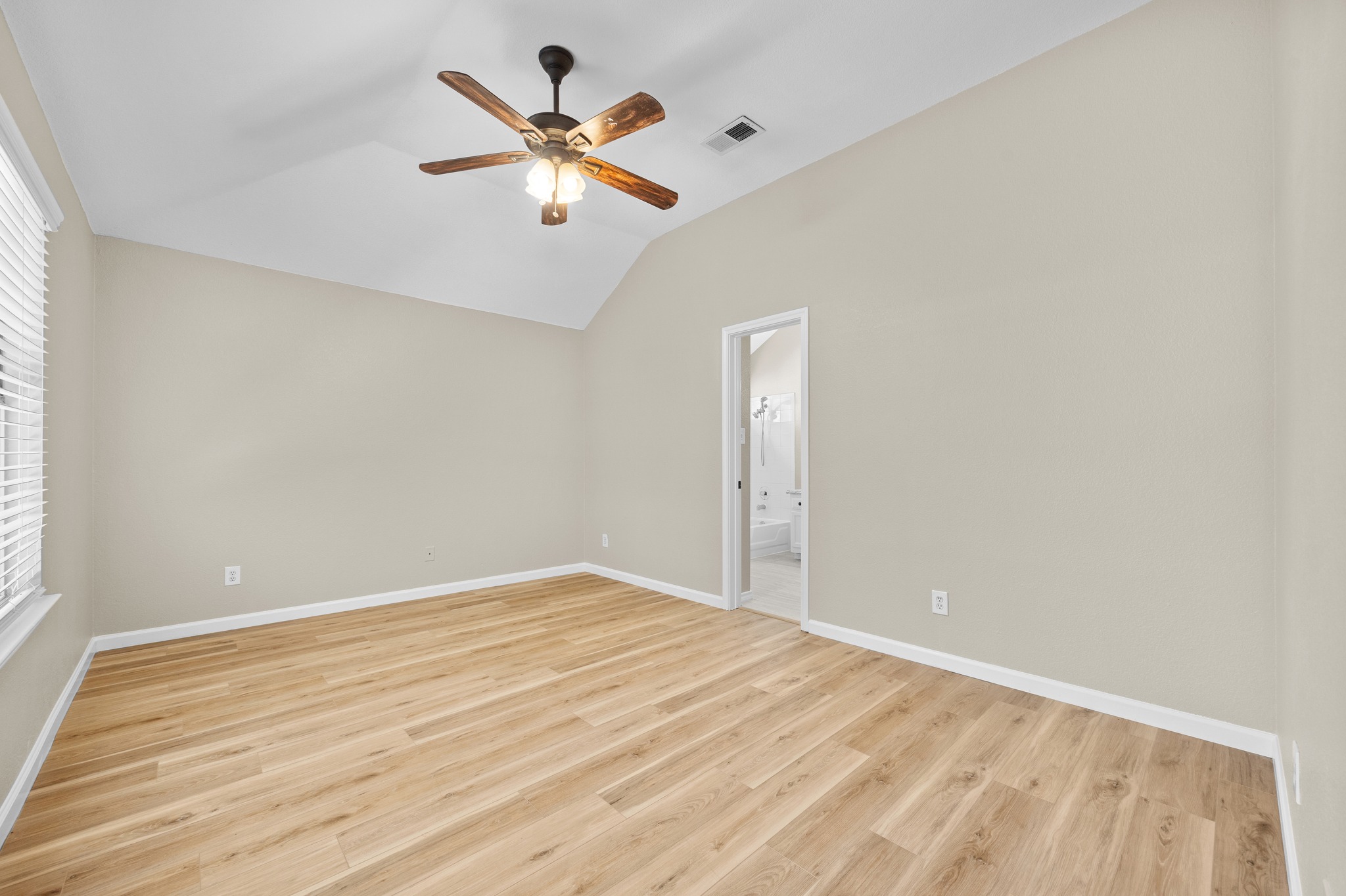 1806 Rusty Nail Loop Round Rock, TX 78681 - Photo 17 of 28 A tranquil bedroom with vaulted ceilings and wood flooring, perfect for unwinding.