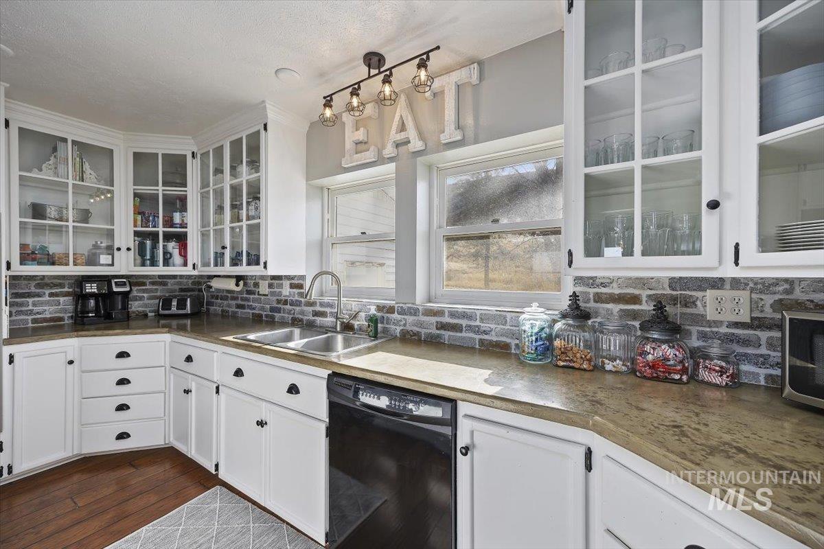 899 East 500th Street South Declo, ID 83323 - Photo 14 of 50 Kitchen featuring glass fronted cabinets, white cabinetry, dishwasher, tasteful backsplash, and dark countertops