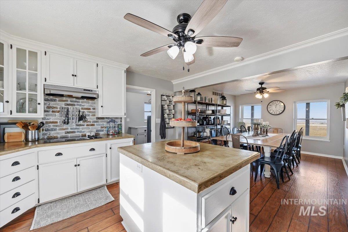 899 East 500th Street South Declo, ID 83323 - Photo 15 of 50 Kitchen with white cabinets, a center island, light wood-style flooring, light countertops, and a textured ceiling
