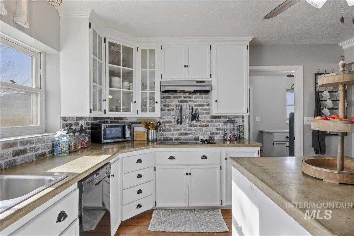 899 East 500th Street South Declo, ID 83323 - Photo 16 of 50 Kitchen with white cabinets, decorative backsplash, dishwasher, glass fronted cabinets, and a textured ceiling
