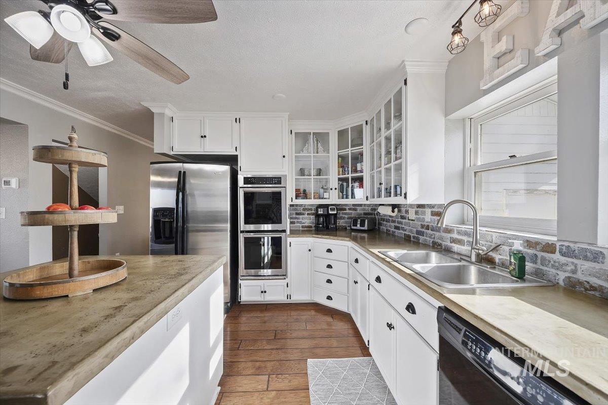 899 East 500th Street South Declo, ID 83323 - Photo 18 of 50 Kitchen with white cabinetry, stainless steel appliances, dark wood-style floors, light countertops, and a textured ceiling