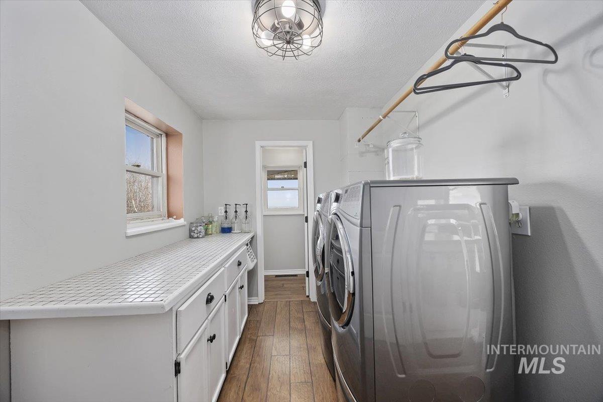 899 East 500th Street South Declo, ID 83323 - Photo 39 of 50 Laundry area featuring dark wood-style flooring, a textured ceiling, washing machine and dryer, and cabinet space