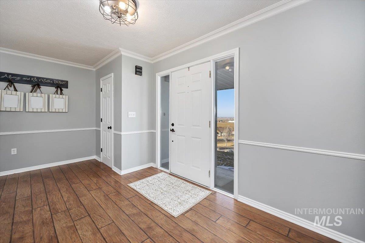 899 East 500th Street South Declo, ID 83323 - Photo 6 of 50 Entrance foyer featuring dark wood-style floors, crown molding, and a textured ceiling