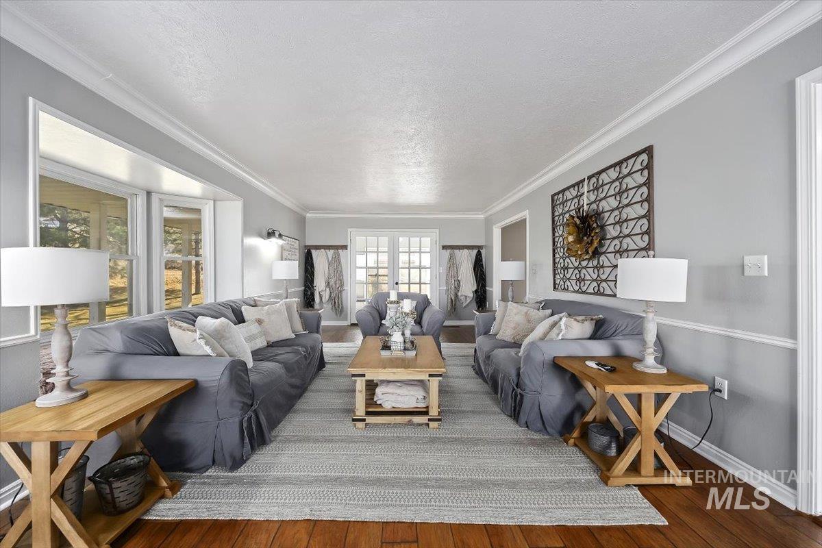 899 East 500th Street South Declo, ID 83323 - Photo 10 of 50 Living area featuring wood finished floors, ornamental molding, and a textured ceiling