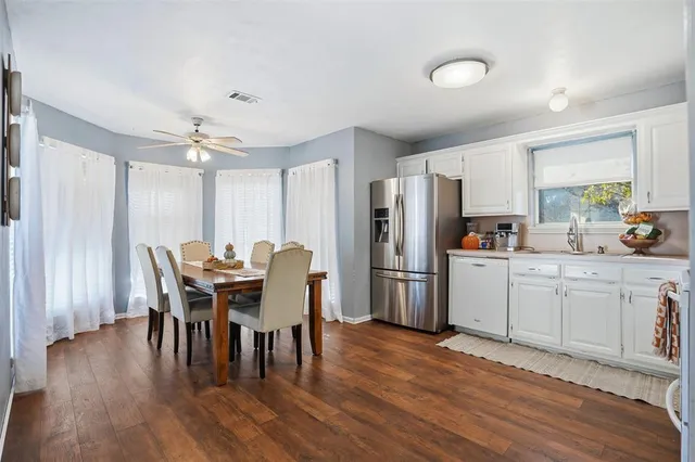 a kitchen with refrigerator a table and chairs