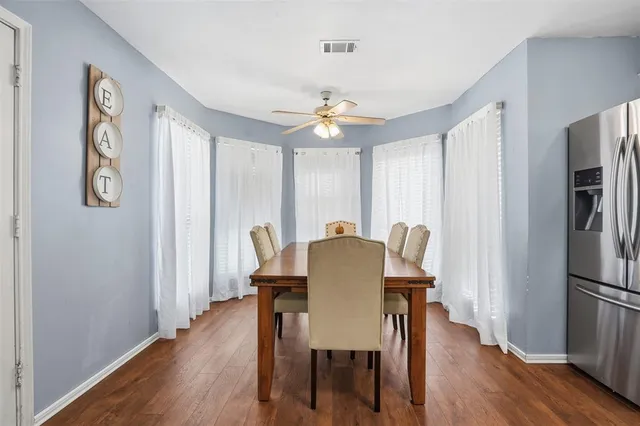 a view of a a dining room with furniture window and wooden floor