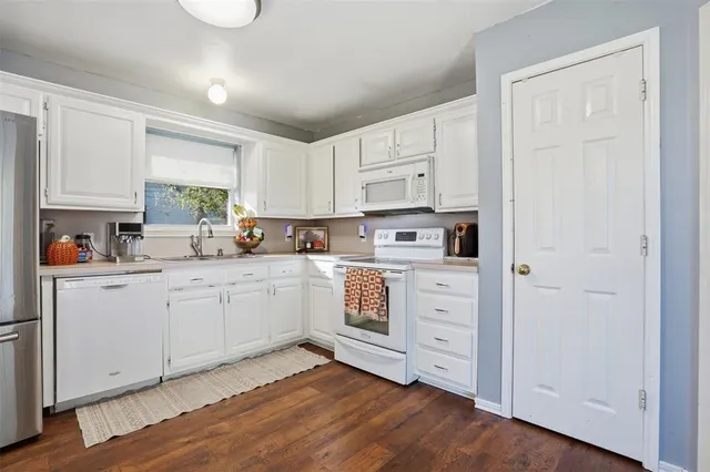 a kitchen with white cabinets and white appliances