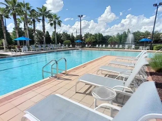 a view of swimming pool with outdoor seating and plants