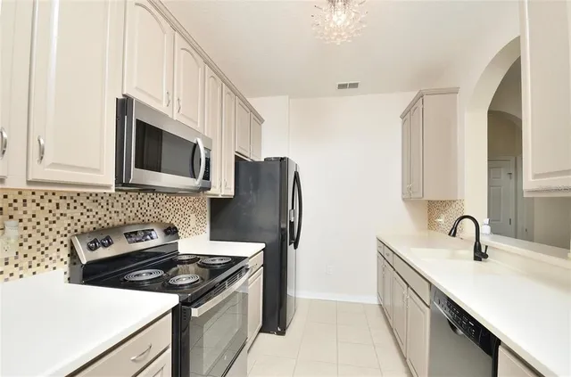 a kitchen with stainless steel appliances a sink stove and microwave