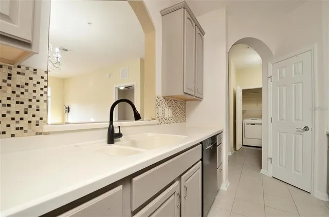 a kitchen with a sink and a large mirror