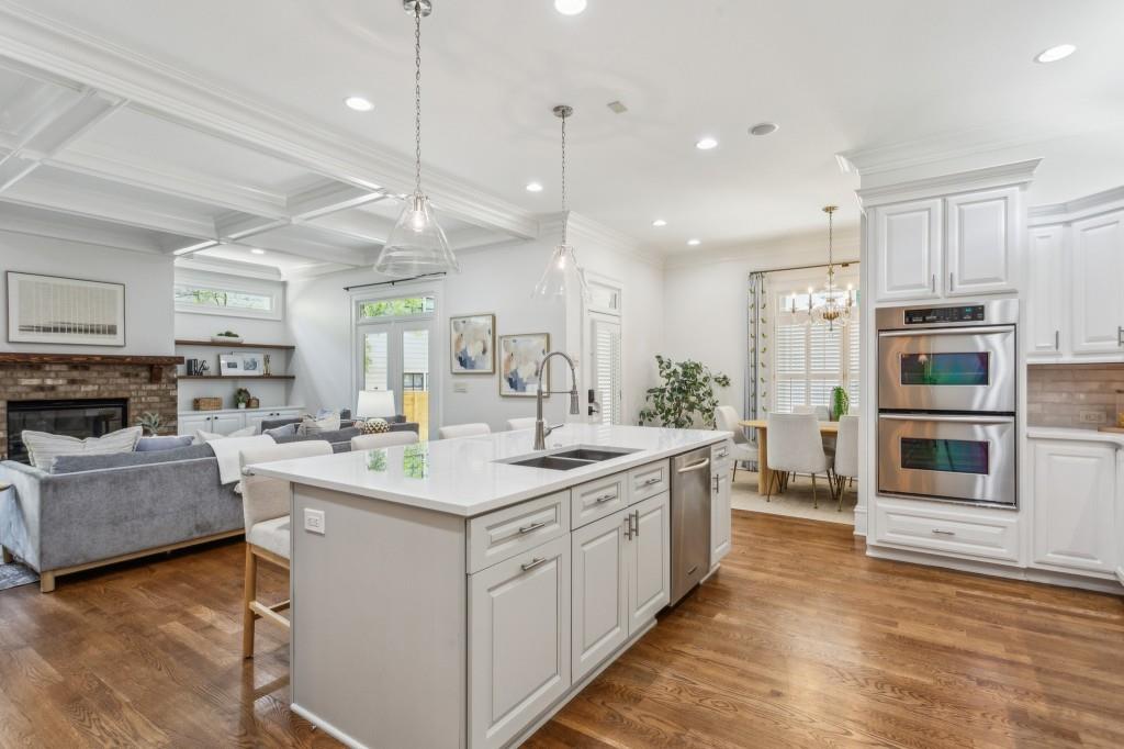 1363 Sylvan Circle Northeast Brookhaven, GA 30319 - Photo 26 of 56 a large white kitchen with stainless steel appliances kitchen island granite countertop a large center island attached withe living room