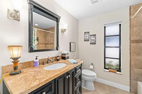 a bathroom with a granite countertop sink toilet and shower