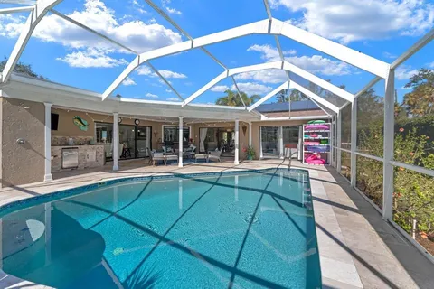 a view of house with swimming pool and glass windows