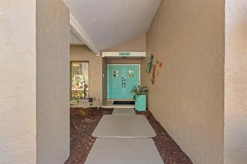 a view of a hallway with wooden floor and a livingroom