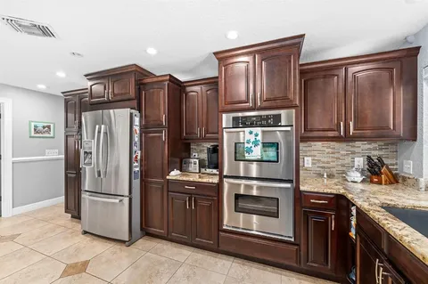 a kitchen with stainless steel appliances granite countertop a refrigerator stove and sink
