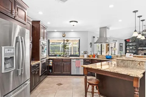 a kitchen with stainless steel appliances granite countertop a stove refrigerator sink and cabinets