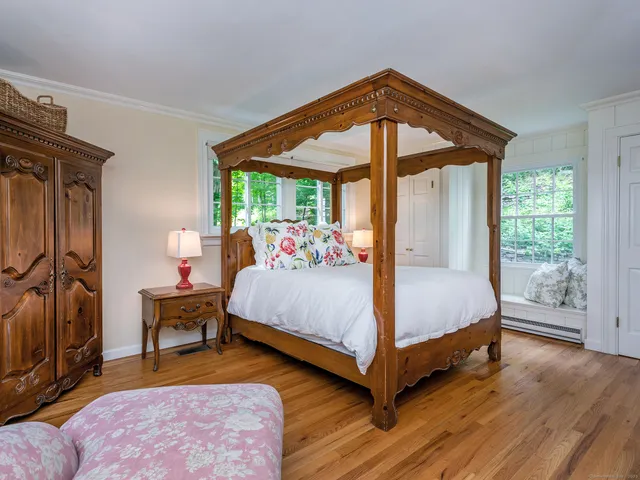 a bedroom with a bed and a large window