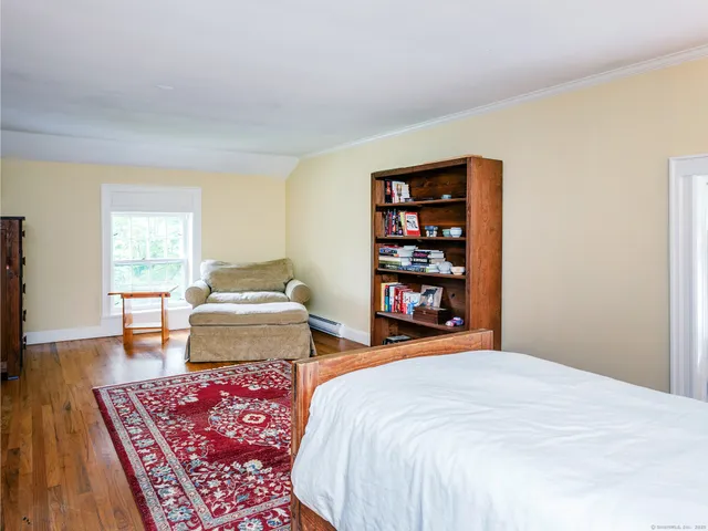 a bedroom with furniture and a book shelf