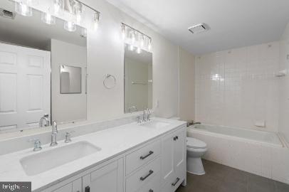 960 Fell Street, Unit 402 Baltimore, MD 21231 - Photo 13 of 18 a bathroom with a double vanity sink toilet mirror and bathtub