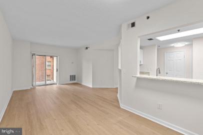 960 Fell Street, Unit 402 Baltimore, MD 21231 - Photo 5 of 18 a view of an empty room with window and wooden floor