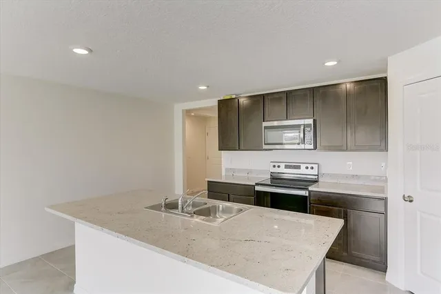 a kitchen with stainless steel appliances granite countertop a sink and a stove