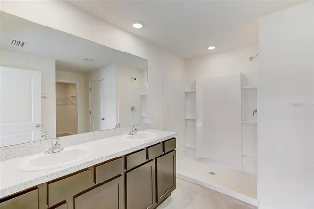 a bathroom with a shower sink and mirror
