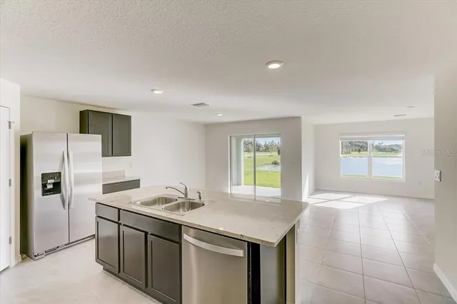 a kitchen with stainless steel appliances granite countertop a sink and a refrigerator