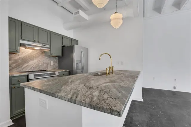 a kitchen with stainless steel appliances granite countertop a sink a refrigerator and a stove