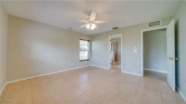 an empty room with fan and windows