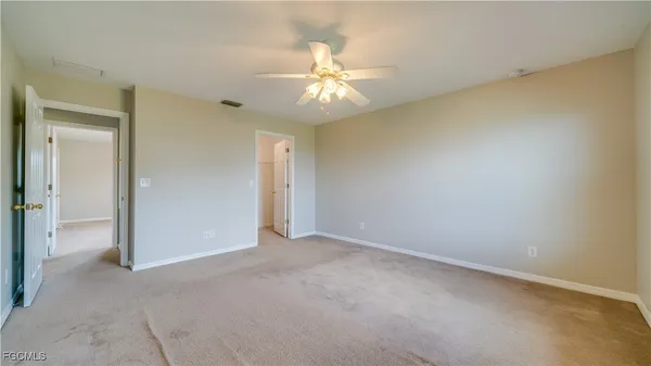 an empty room with closet and a chandelier fan