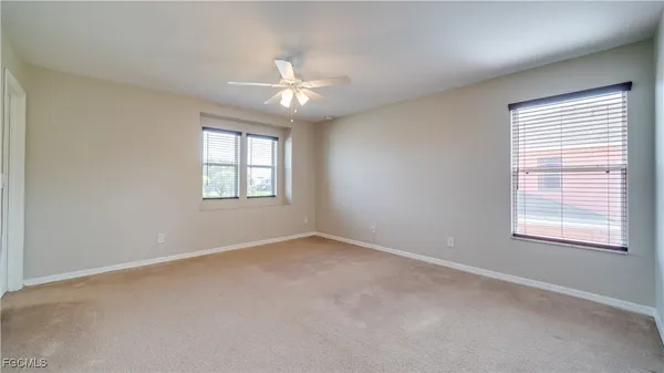 an empty room with windows and fan