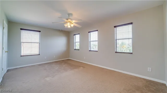 an empty room with windows and fan