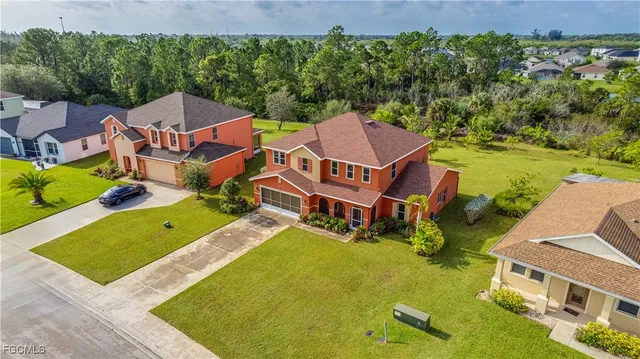 an aerial view of a house with swimming pool and large trees