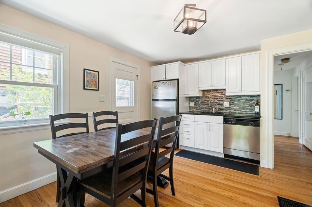 11 Sunset Road Arlington, MA 02474 - Photo 8 of 27 a kitchen with a table chairs refrigerator and cabinets