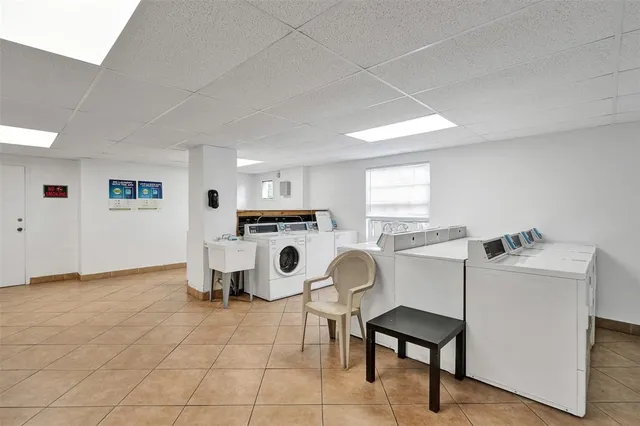 a living room with furniture a washing machine and a table