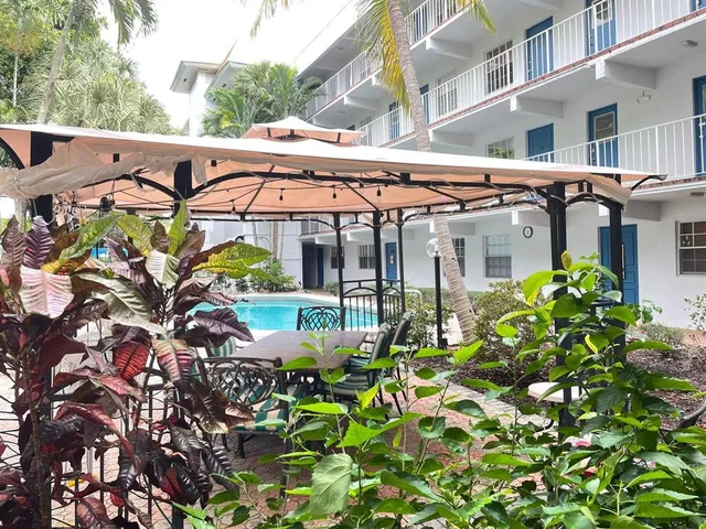a view of a patio with table and chairs under an umbrella