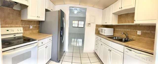 a kitchen with granite countertop a sink stove and cabinets
